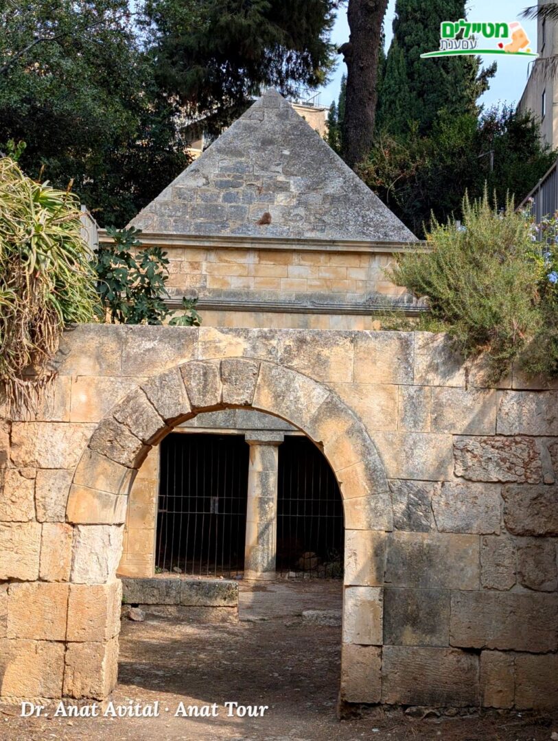שער הקשת של קבר יאסון, ומאחוריו חזית המבוא עם העמוד והמונומנט הפירמידלי